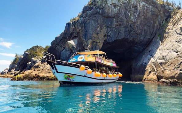 Boat entering Gruta Azul cave on tour in Arraial do Cabo, Brazil.