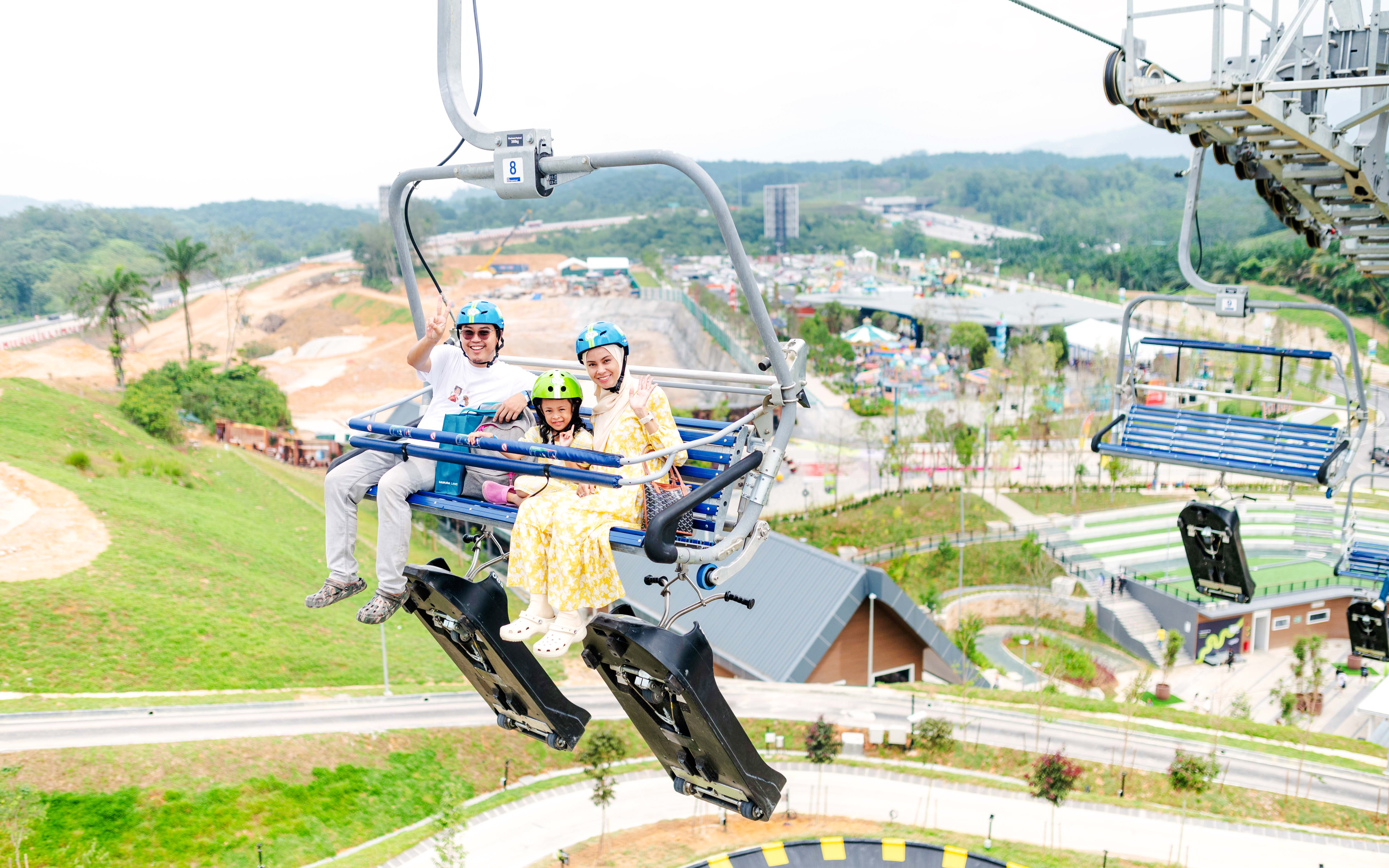 Family on chairlift at Skyline Luge Kuala Lumpur with scenic view.