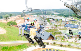 Family on chairlift at Skyline Luge Kuala Lumpur with scenic view.