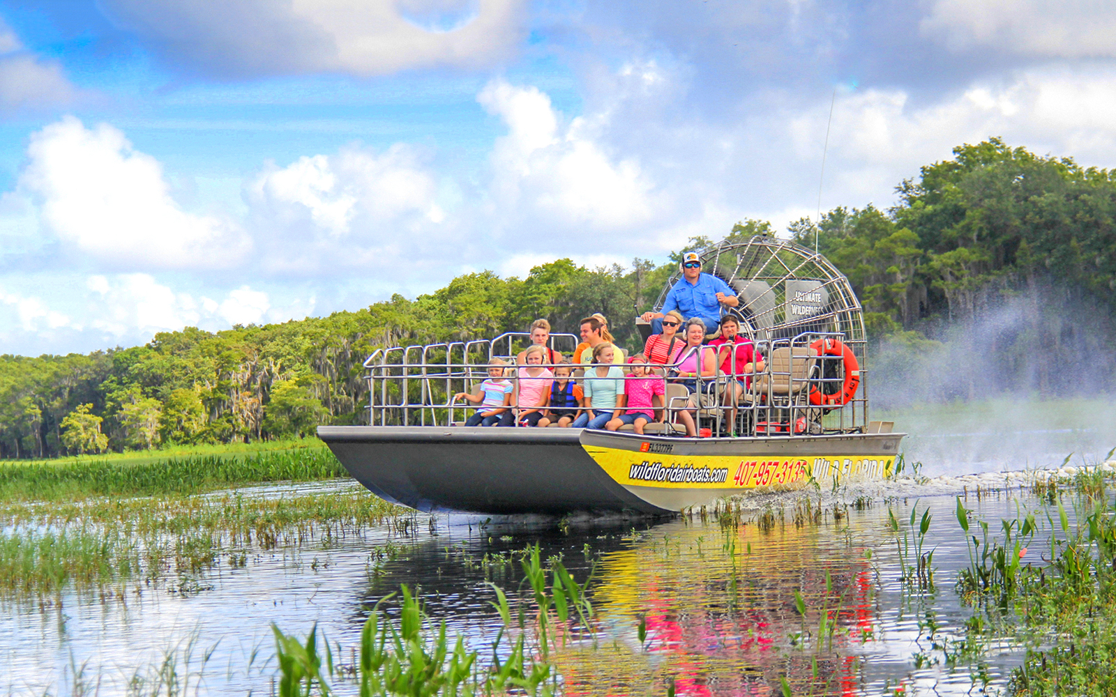 Guests on an airboat tour enjoying the Everglades view.