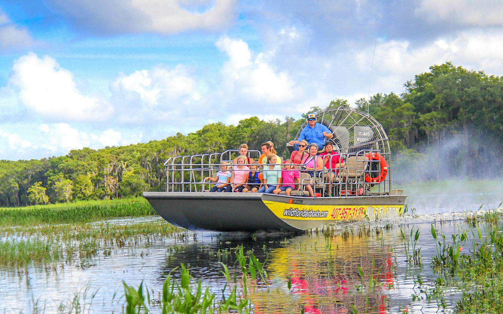 Guests on an airboat tour enjoying the Everglades view.