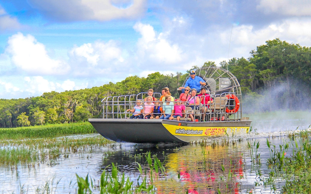 Guests on an airboat tour enjoying the Everglades view.