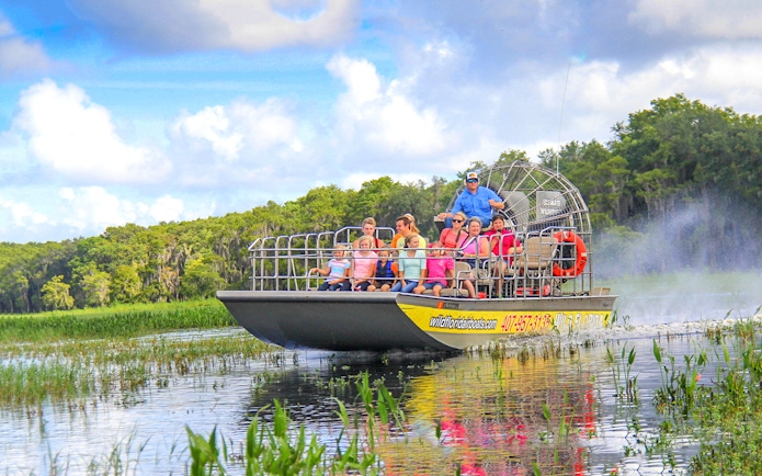 Guests on an airboat tour enjoying the Everglades view.