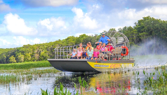 Guests on an airboat tour enjoying the Everglades view.