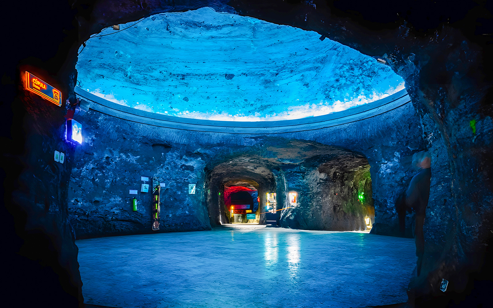 Dome area of Salt Cathedral of Zipaquirá with illuminated blue ceiling.