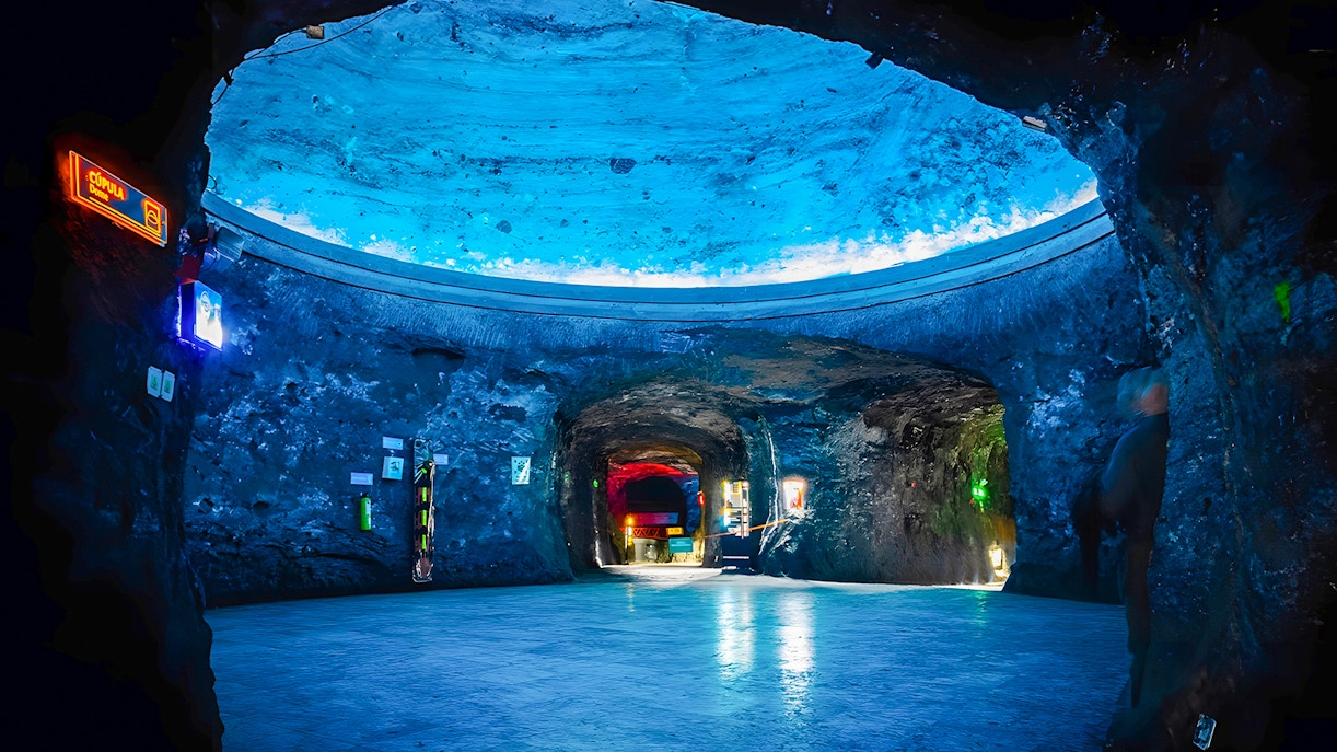 Dome area of Salt Cathedral of Zipaquirá with illuminated blue ceiling.