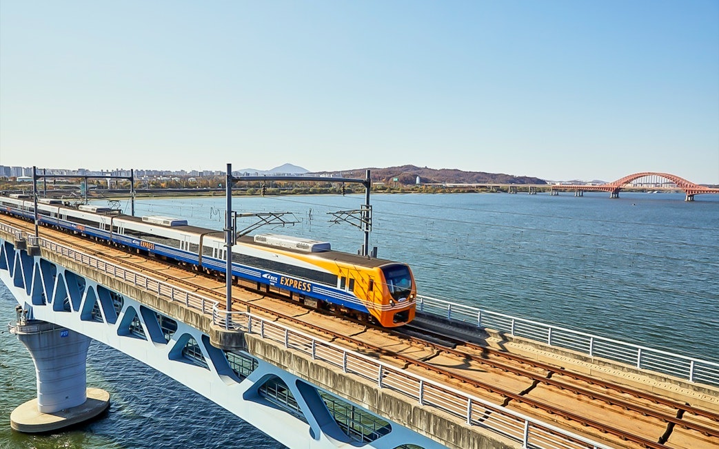 AREX Express train crossing a bridge over a river in Seoul, South Korea.