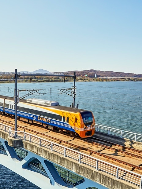 AREX Express train crossing a bridge over a river in Seoul, South Korea.