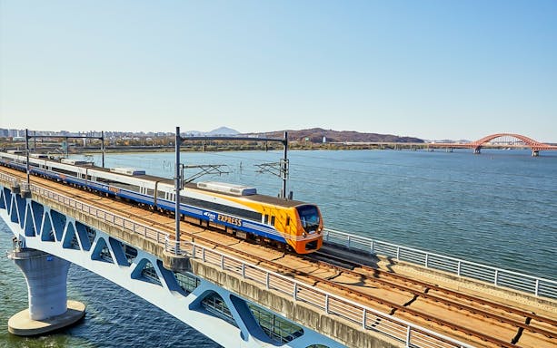 AREX Express train crossing a bridge over a river in Seoul, South Korea.