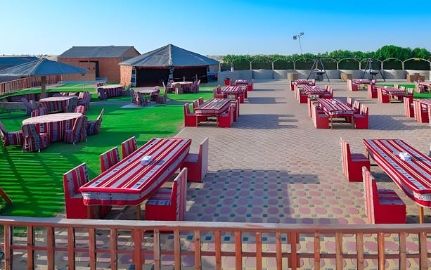 Desert safari seating area with traditional red-striped cushions and tables.