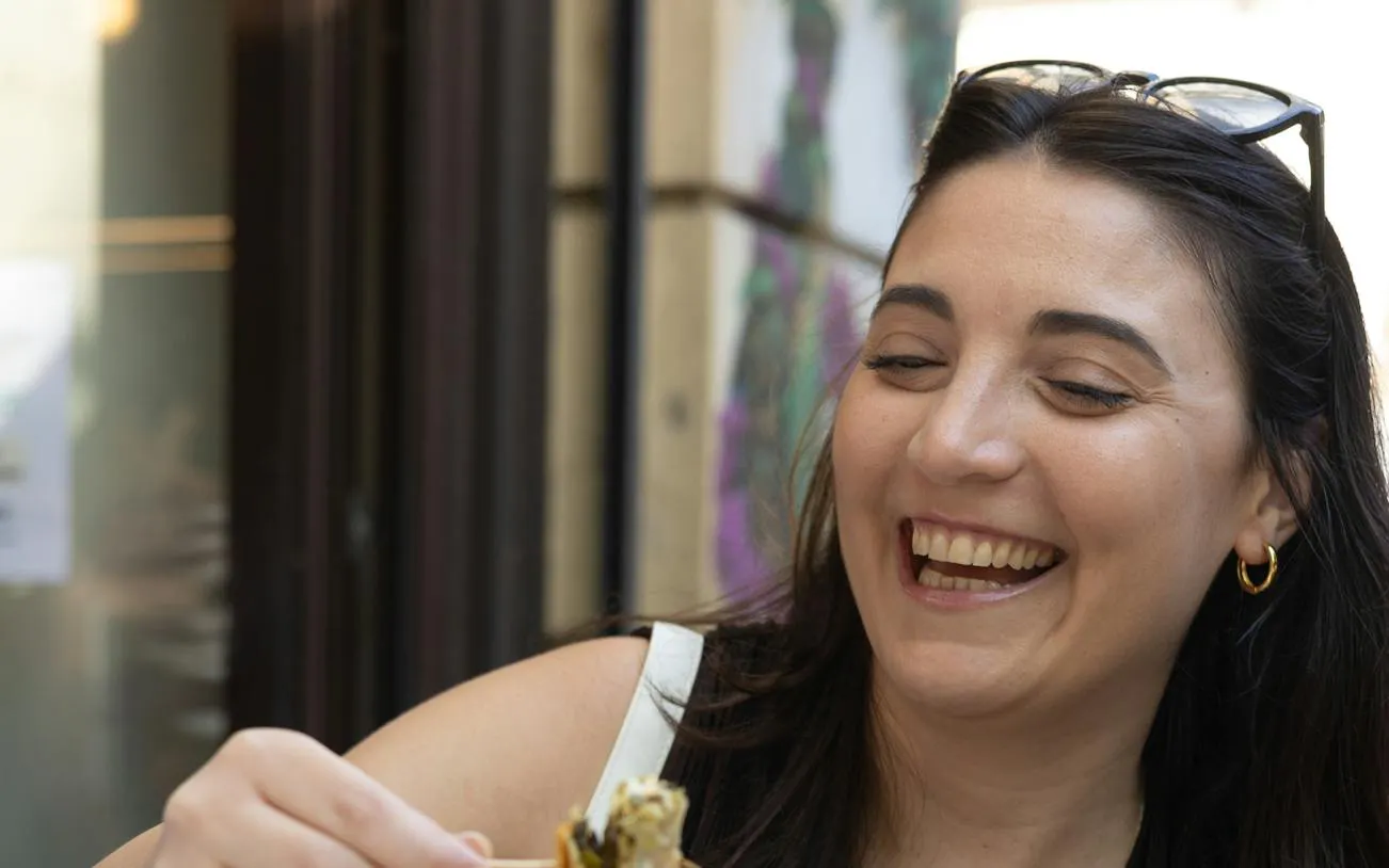 Smiling person enjoying food during Athens evening food tour.