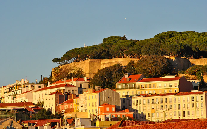 Lisbon's Alfama district with São Jorge Castle viewed from the Tagus River.