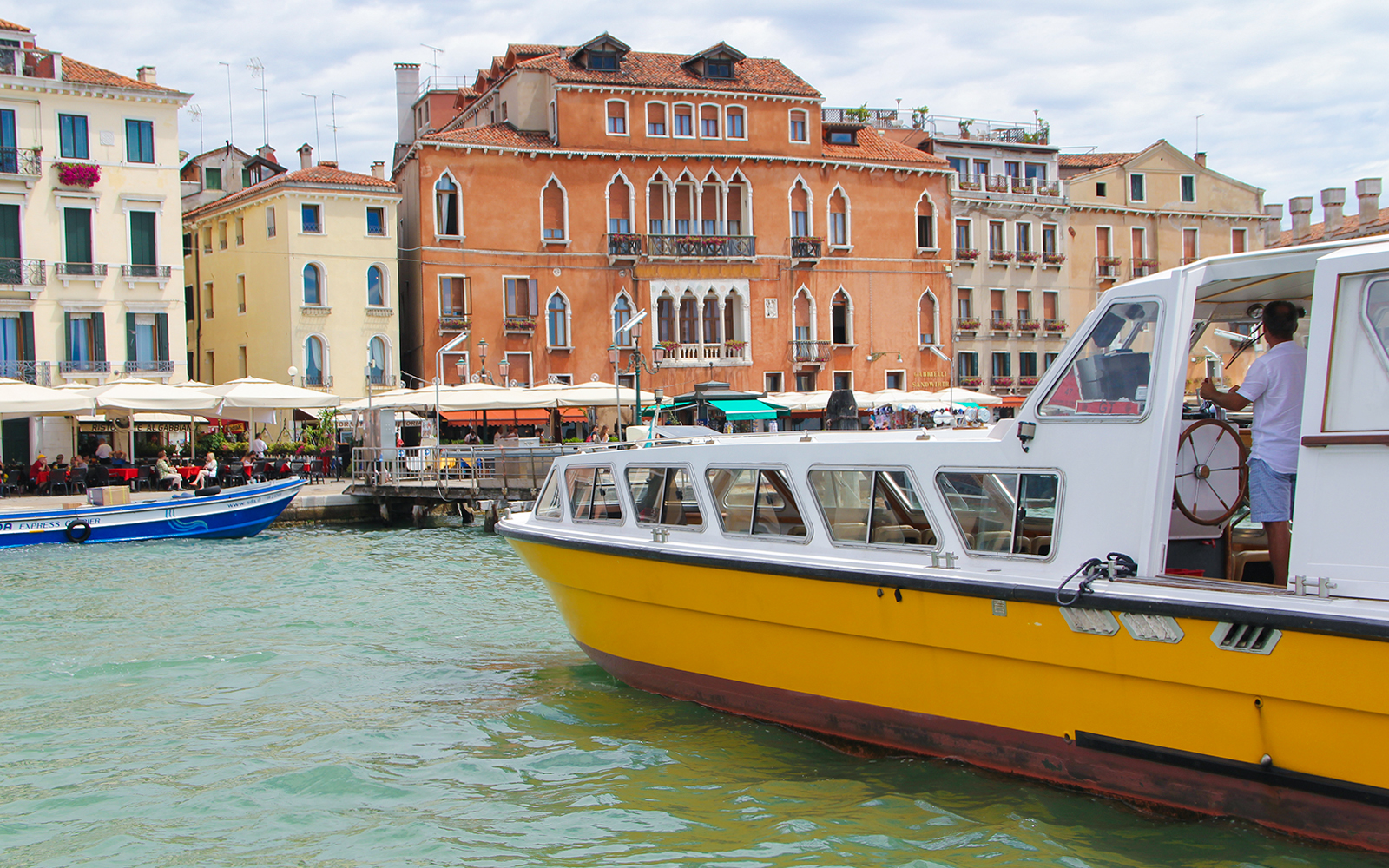 Alilaguna Water Bus docked near colorful Venetian buildings in Venice, Italy.