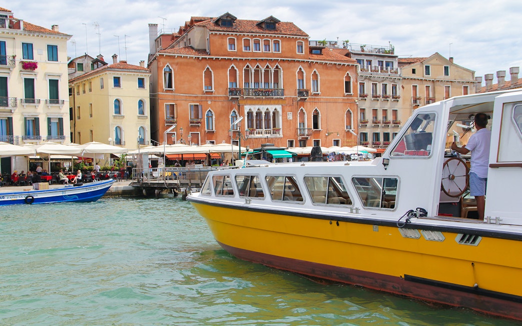 Alilaguna Water Bus docked near colorful Venetian buildings in Venice, Italy.