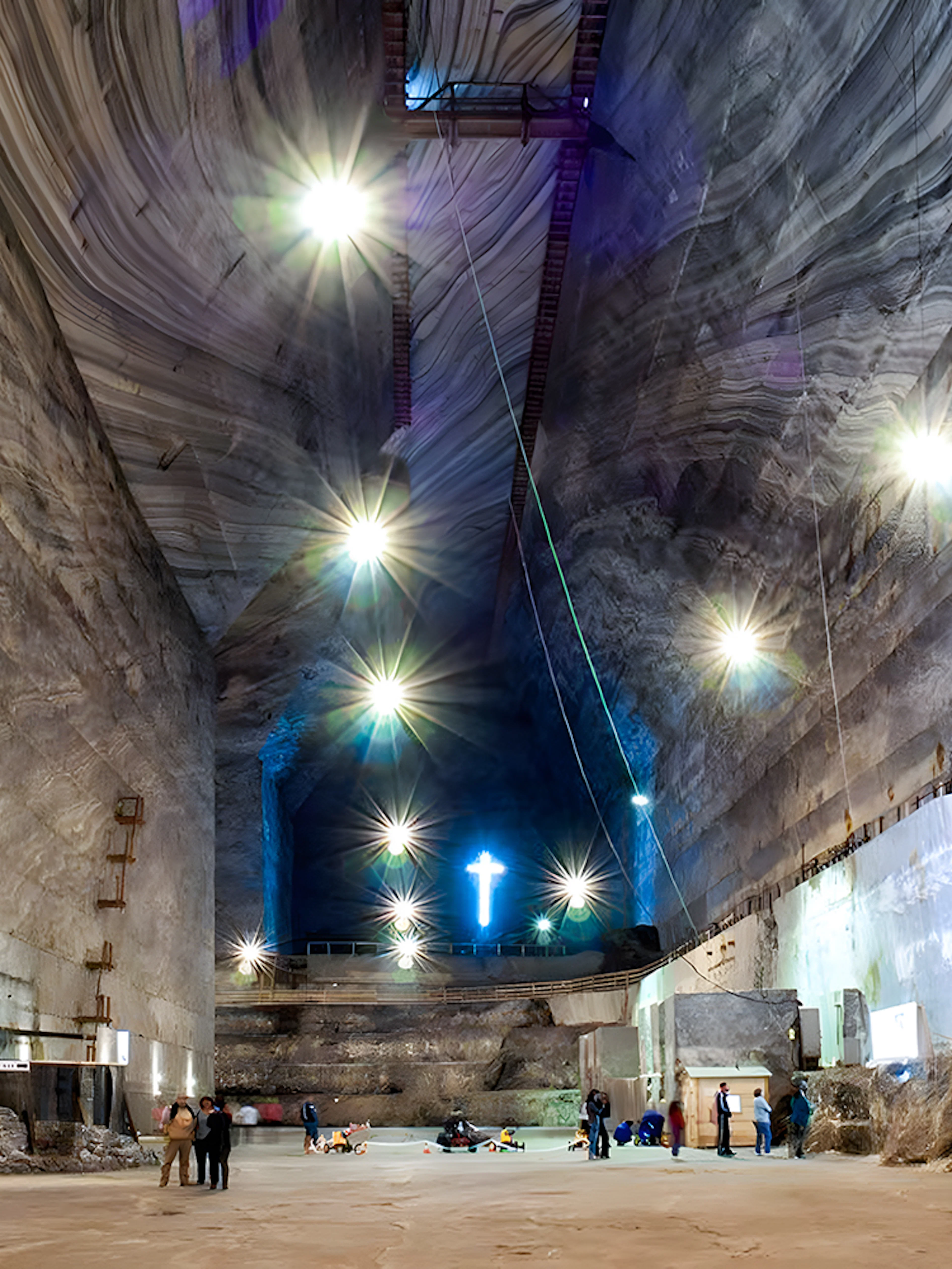 Slanic Salt Mine interior with visitors exploring illuminated cavern, Romania.