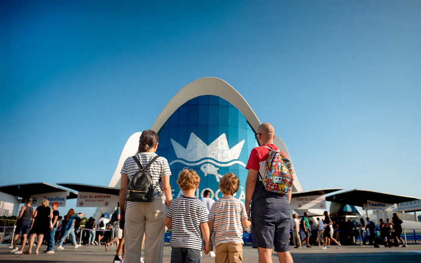 Visitors entering Oceanogràfic Valencia with iconic blue building in background.