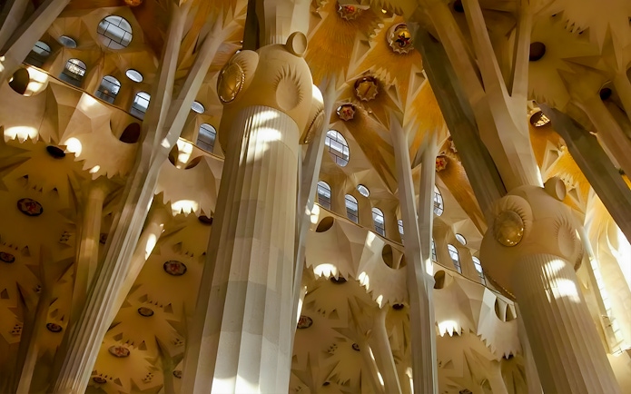 Sagrada Familia interior columns with intricate design and natural light filtering through.