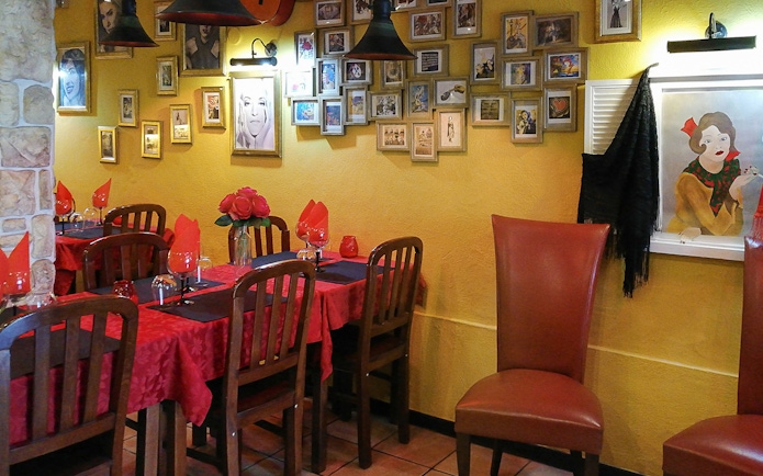 Lisbon restaurant with red table settings and Fado-themed decor for Alfama tour dinner.