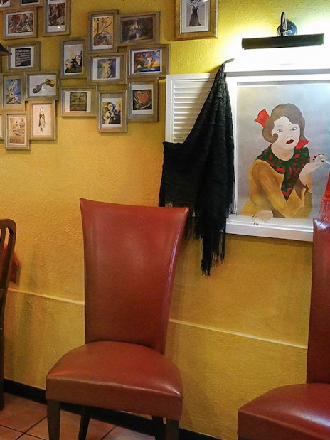 Lisbon restaurant with red table settings and Fado-themed decor for Alfama tour dinner.