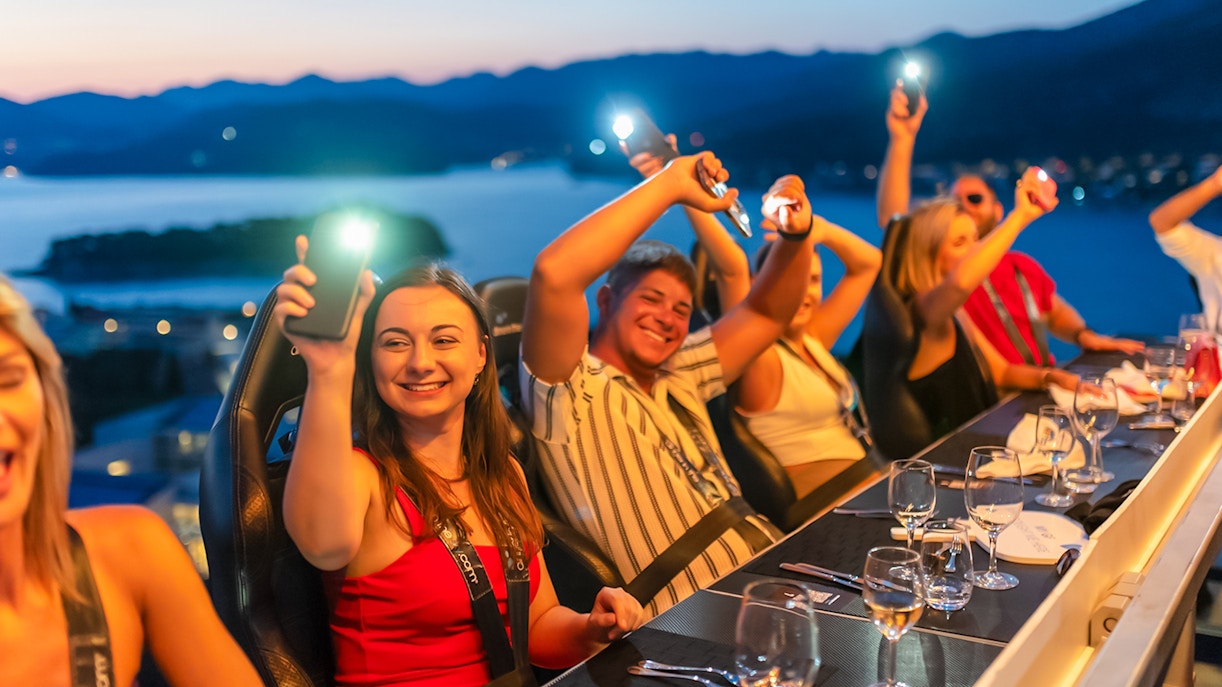 Guests dining at Dinner in the Sky with a view of Dubrovnik at sunset.