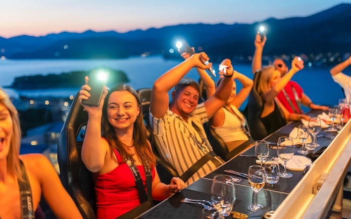 Guests dining at Dinner in the Sky with a view of Dubrovnik at sunset.