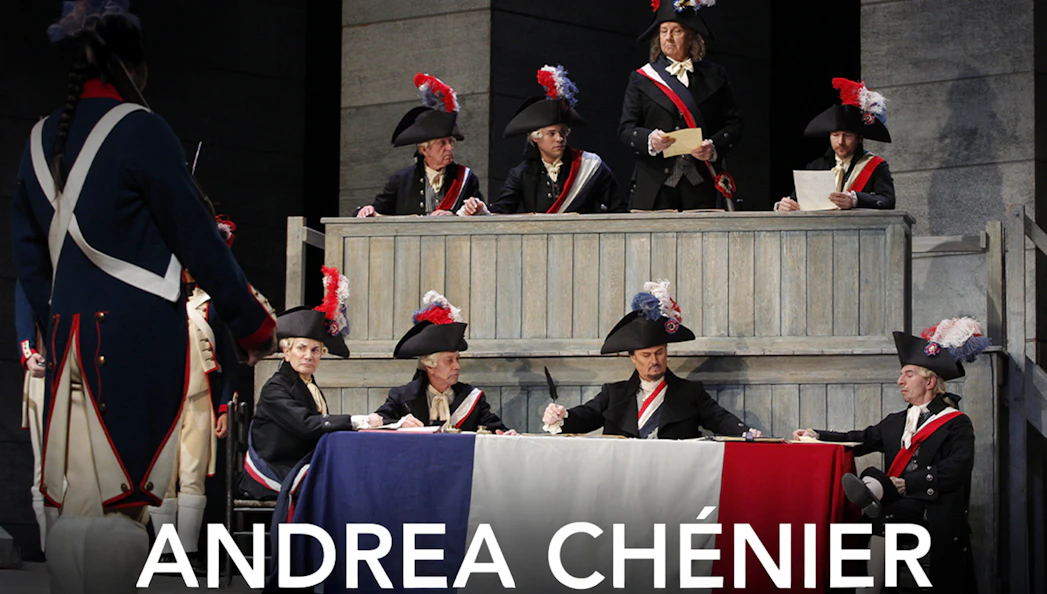 Opera scene from Andrea Chénier with actors in period costumes and tricolor flag.