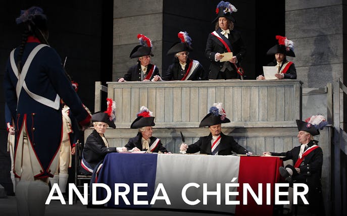 Opera scene from Andrea Chénier with actors in period costumes and tricolor flag.