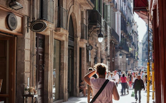 Crowded street in Barcelona's Gothic Quarter shopping area with historic buildings.