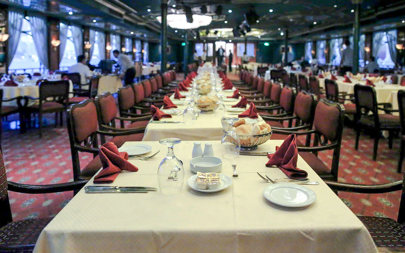 Luxury Nile Dinner Cruise dining area with elegantly set tables and red napkins.
