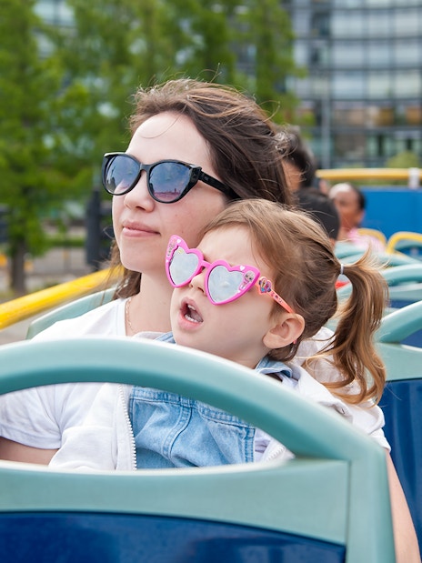 Children on a Tootbus tour in London with a live guide, passing city landmarks.