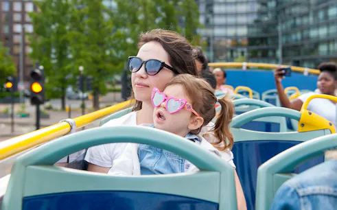 Children on a Tootbus tour in London with a live guide, passing city landmarks.