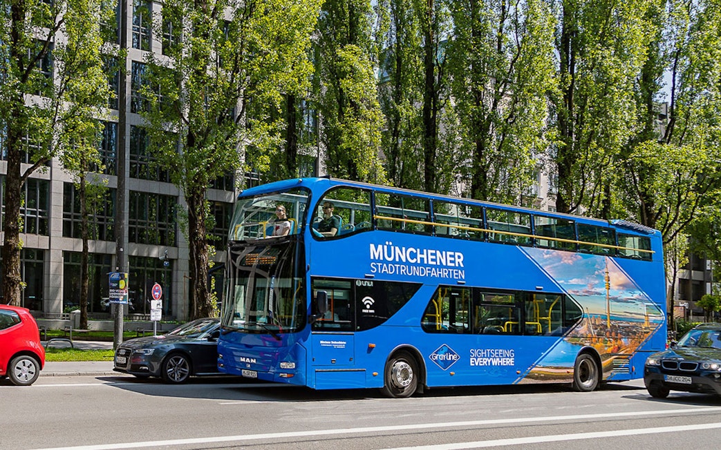 Tourists on a blue double-decker bus during Munich Hop-On Hop-Off tour.