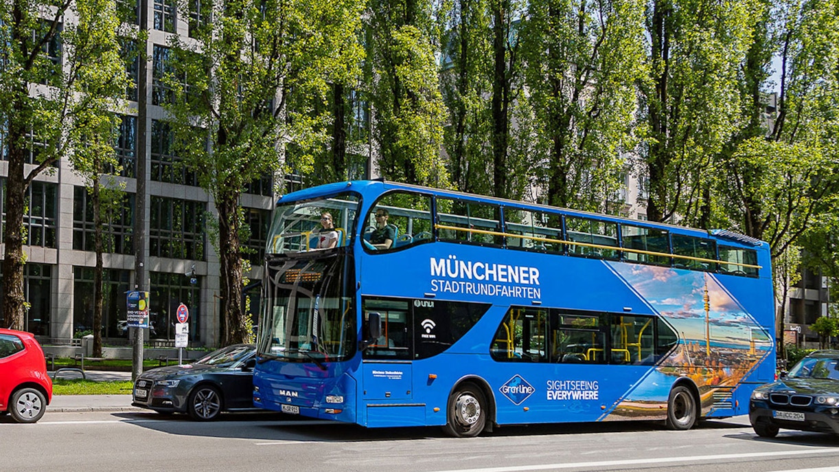 Tourists on Big Bus Munich tour passing by Marienplatz and Neues Rathaus.