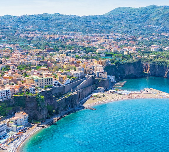 Aerial view of Sorrento coastline with cliffs and buildings, part of Rome to Naples tours.