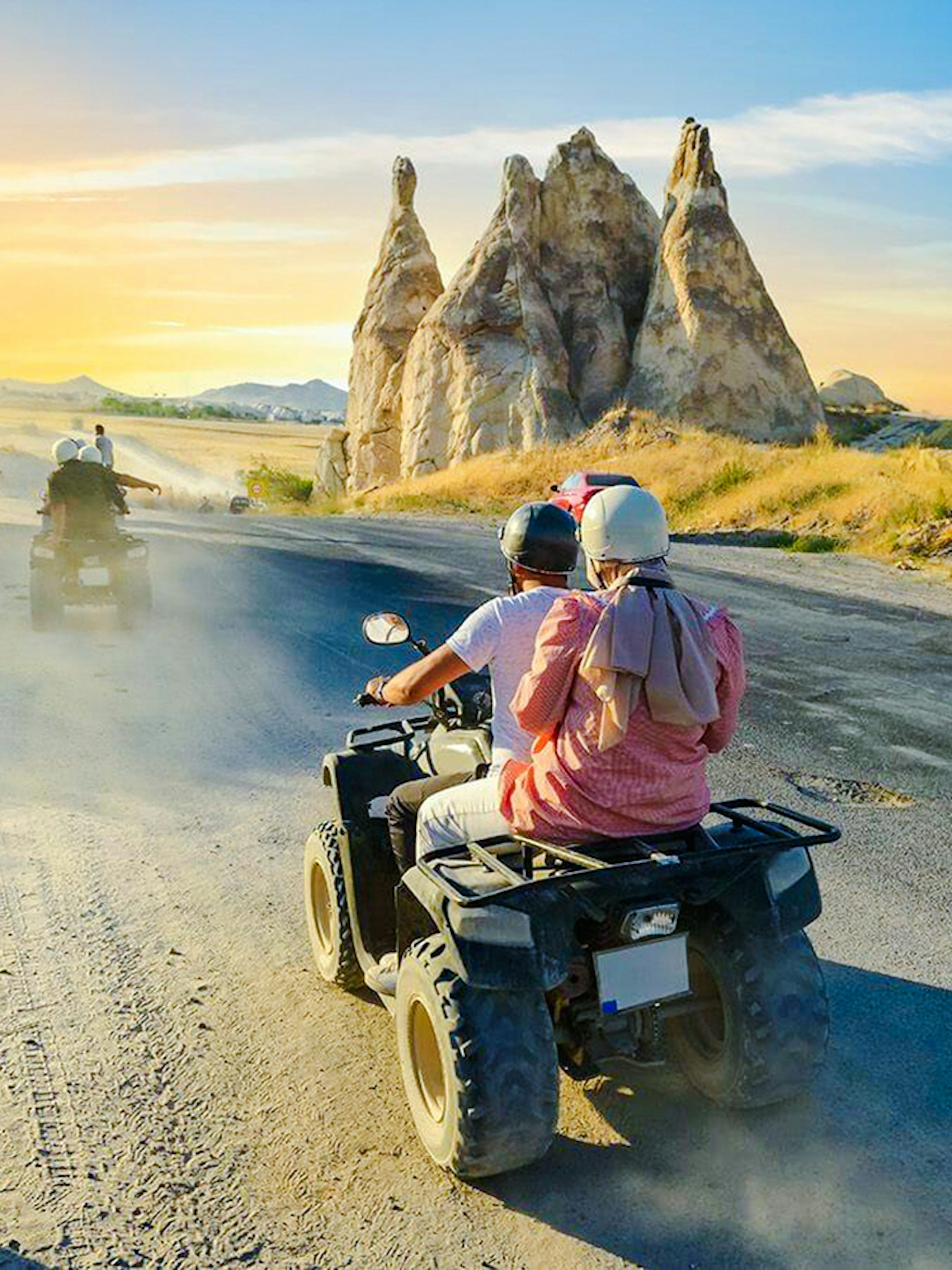 ATV riders exploring Cappadocia's unique rock formations at sunset.