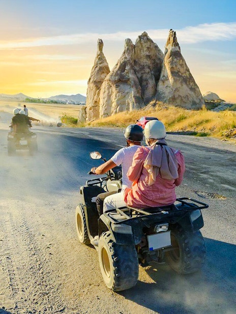 ATV riders exploring Cappadocia's unique rock formations at sunset.