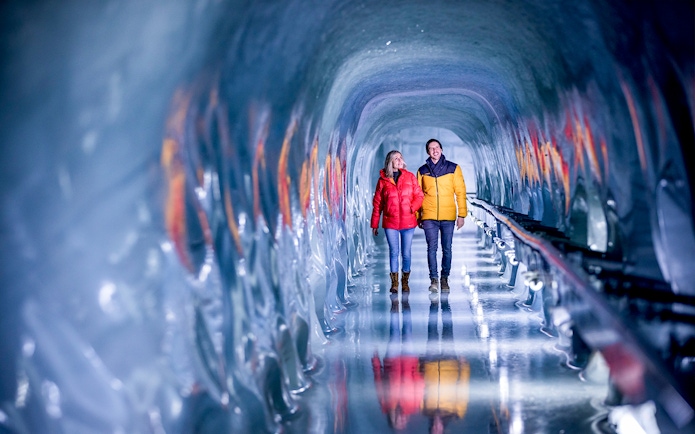 Couple walking through ice tunnel at Jungfraujoch, Switzerland.