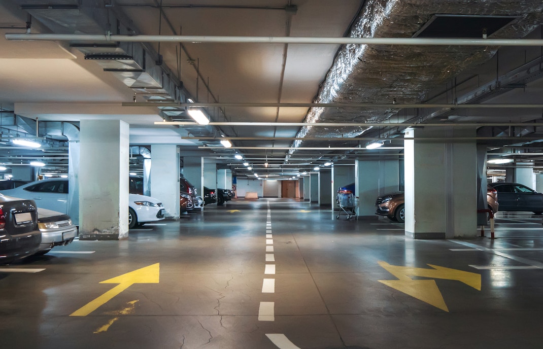 Parking garage entrance with directional signs in a city center.