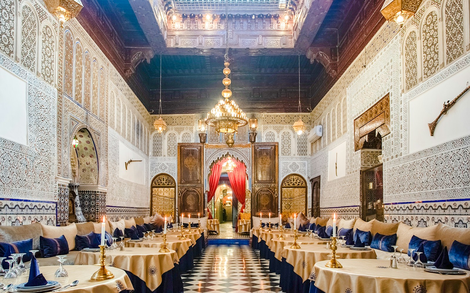 Dar Essalam Moroccan restaurant interior with ornate decor and candlelit tables.