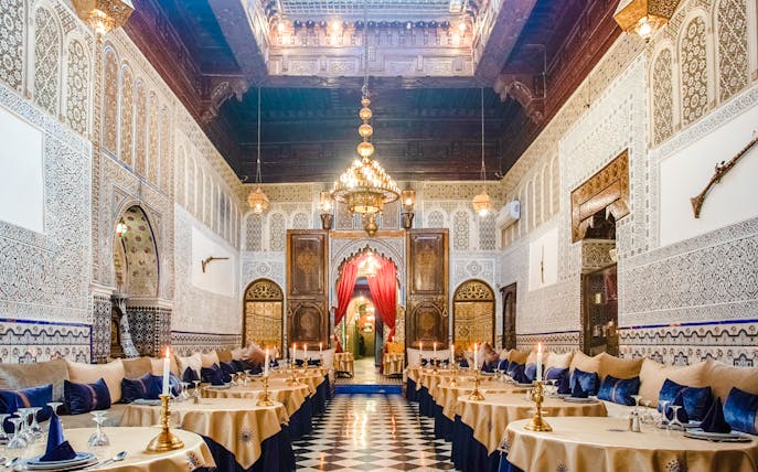 Dar Essalam Moroccan restaurant interior with ornate decor and candlelit tables.