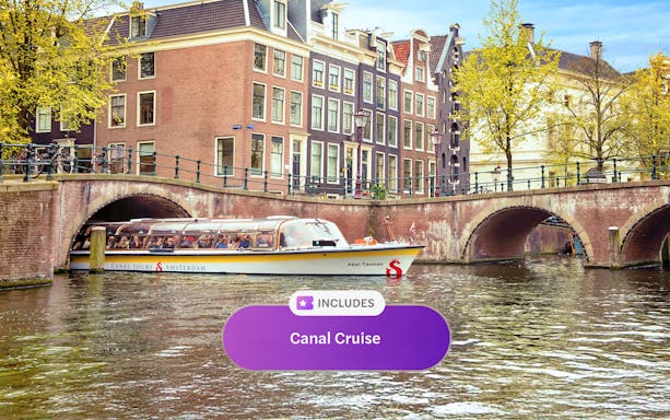 Canal cruise boat on Amsterdam canal with historic buildings and bridge.