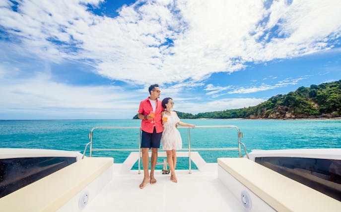 Couple enjoying drinks on a power catamaran near Phi Phi and Maithon Islands, Phuket.