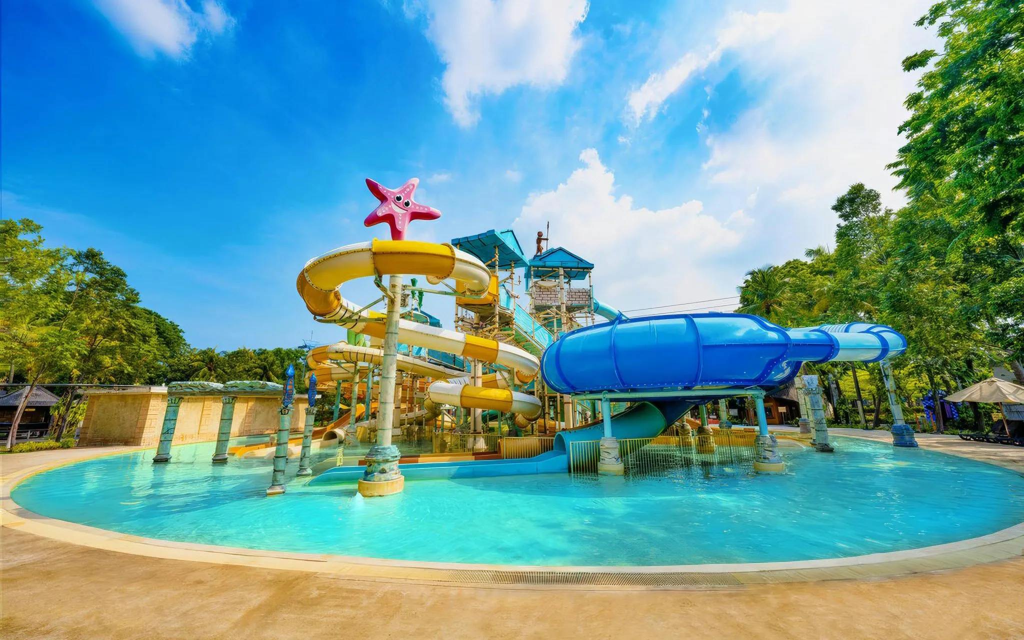 Water slides at Atlantis Water Adventure Park Ancol, featuring colorful tubes and a starfish decoration.