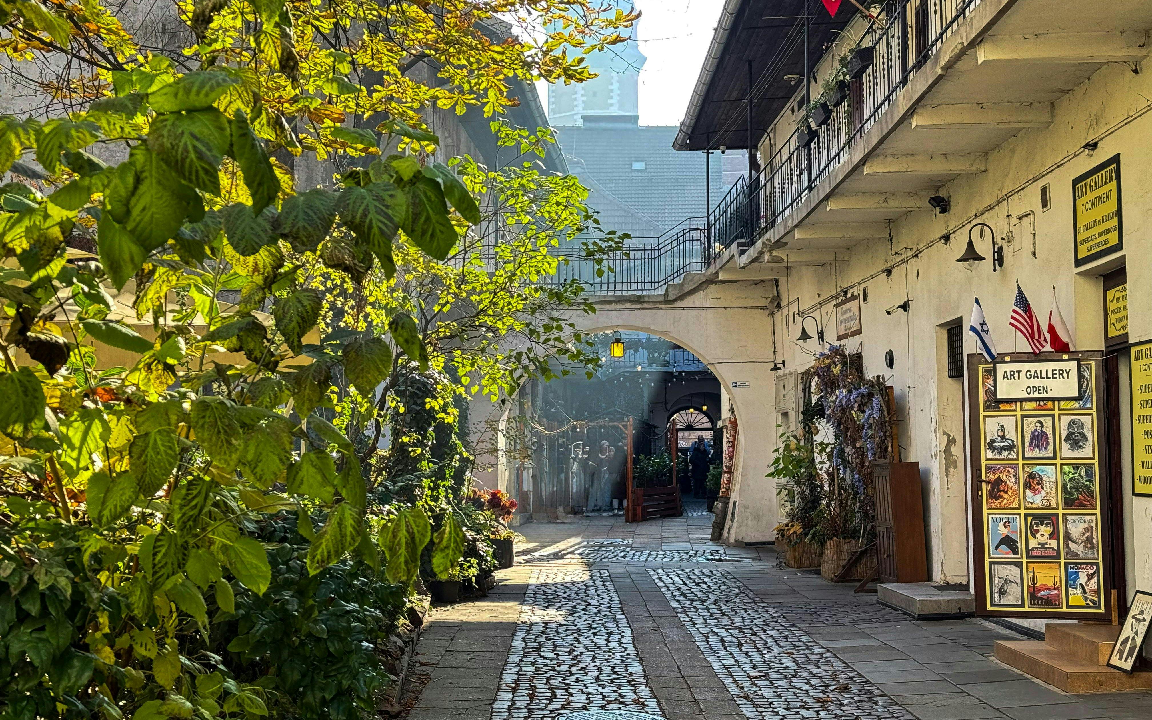 Krakow Kazimierz street with art gallery and cobblestone path on Schindler’s Story tour.