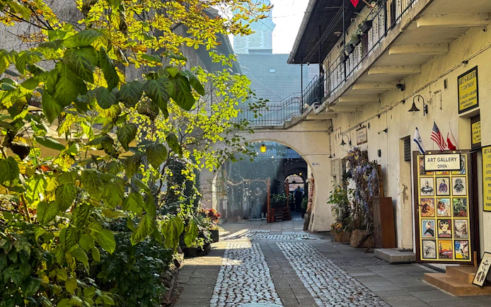Krakow Kazimierz street with art gallery and cobblestone path on Schindler’s Story tour.