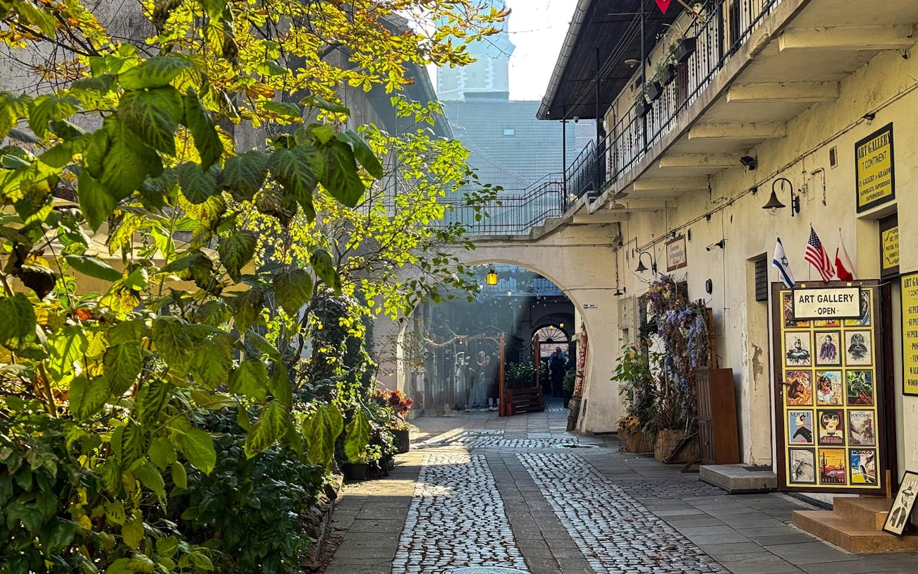 Krakow Kazimierz street with art gallery and cobblestone path on Schindler’s Story tour.