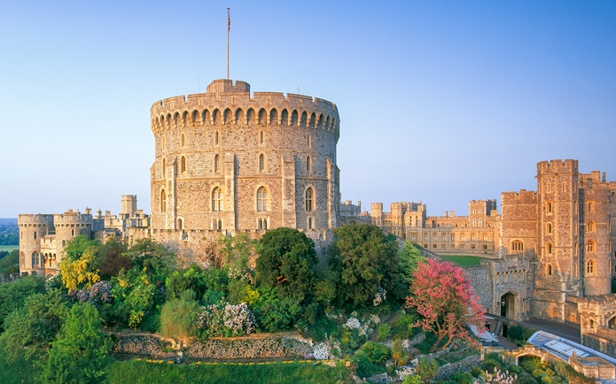 Round Tower at Windsor Castle surrounded by lush gardens, England.