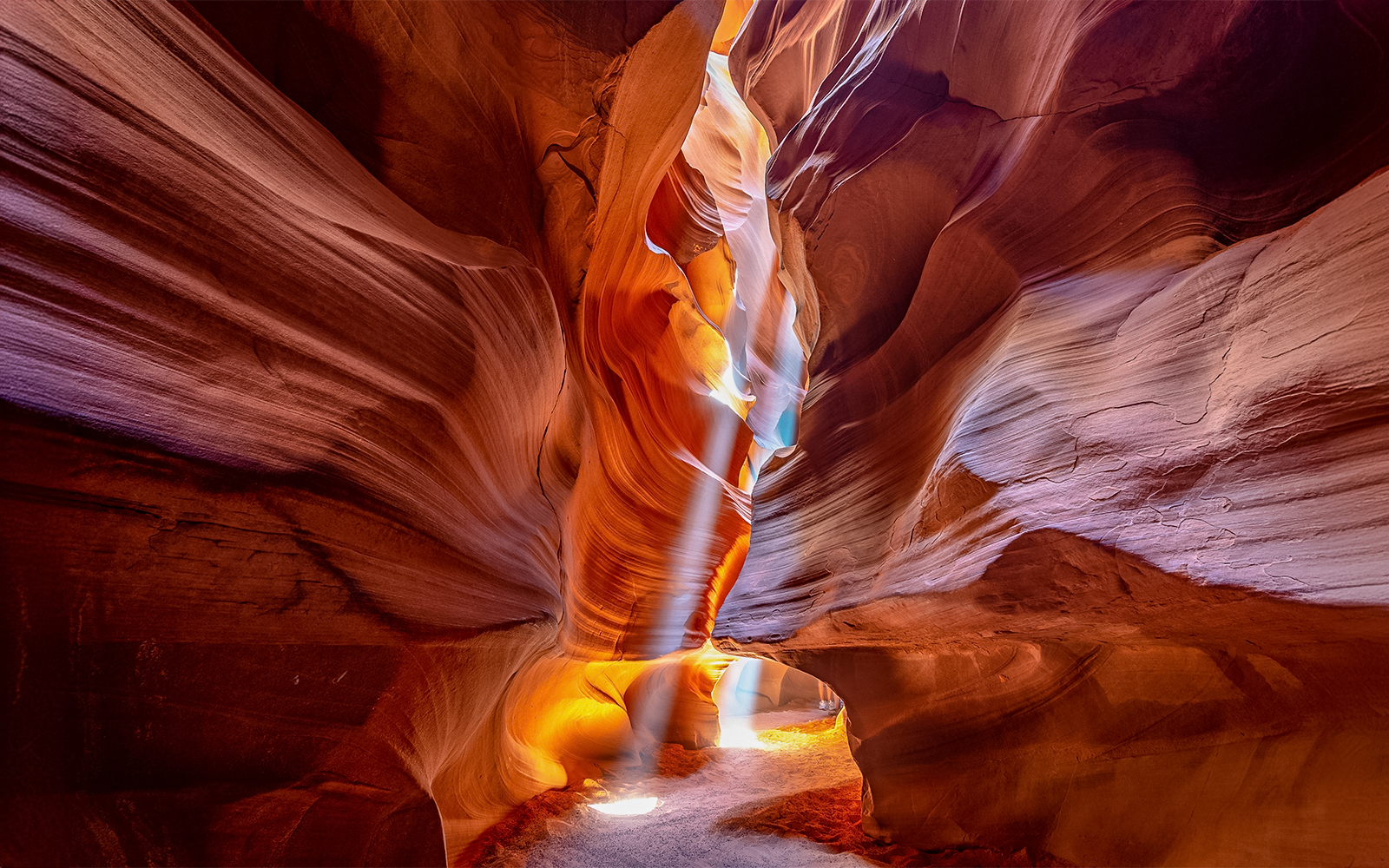 Narrow pathway through Upper Antelope Canyon with sunlight streaming through.