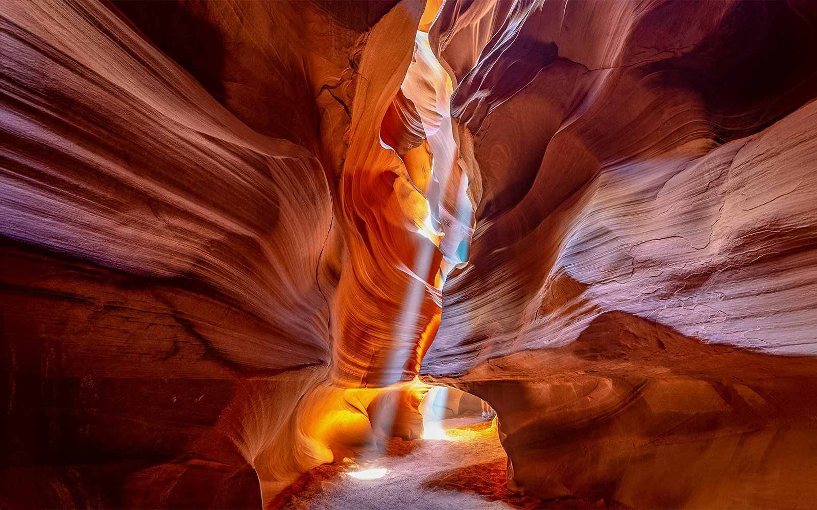 Turistas explorando las fascinantes formaciones de arenisca en el interior del cañón del Antílope superior, un popular destino incluido en los tours por el Cañón del Antílope.