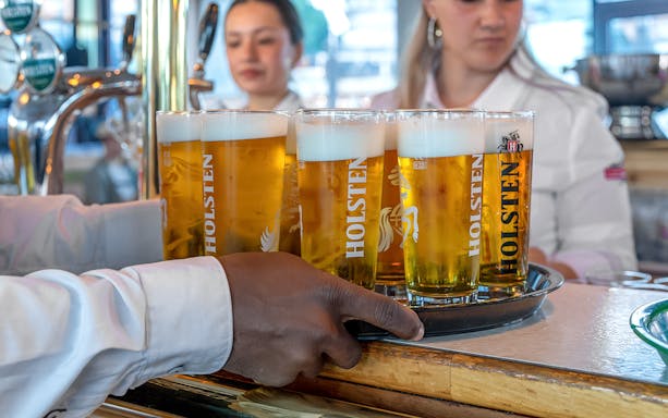 Serving Holsten beers on a tray during Hamburg boat party.